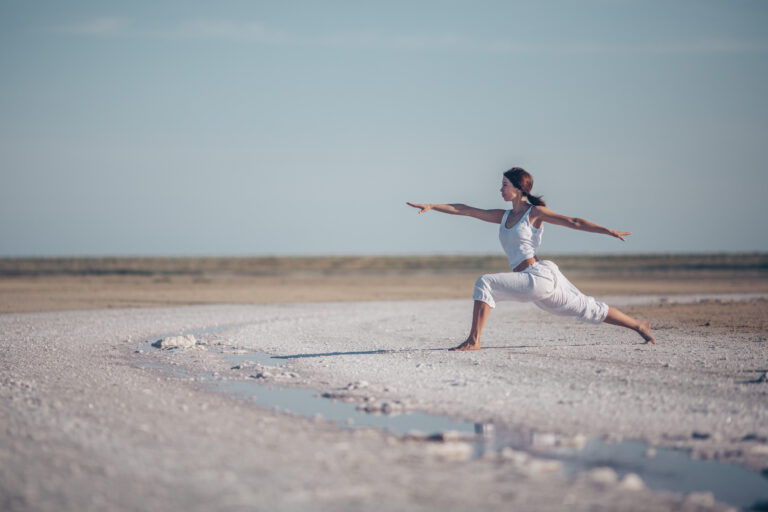 Woman lying in savasana on a yoga mat with eyes closed, practicing deep relaxation.